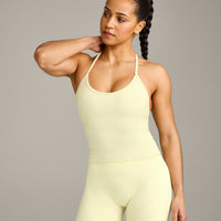 EnhanceLift™ Seamless Strappy Racer Vest with Built in Bra Shelf with Grey Logo | Pastel Yellow